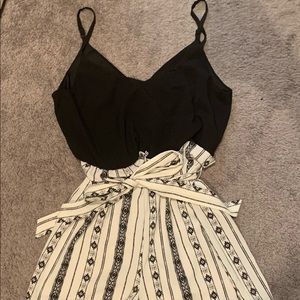 Shorts-Romper with Black top section and black and white patterned bottom.